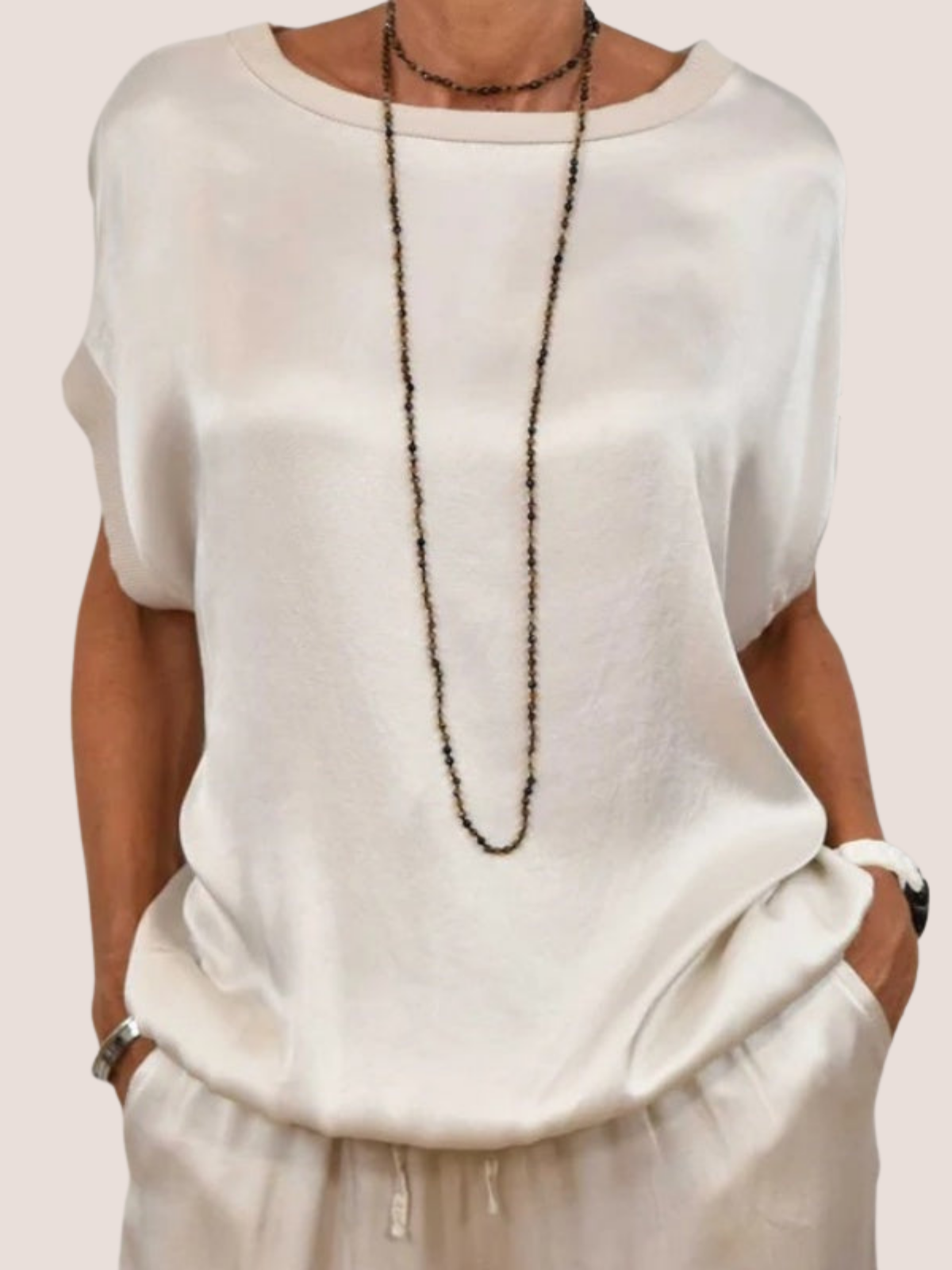 Women's white satin two-piece set, close-up of relaxed fit top with drawstring pants